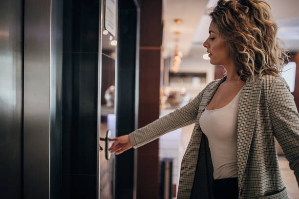 istock Young businesswoman calling the elevator in hotel lobby 1252028540