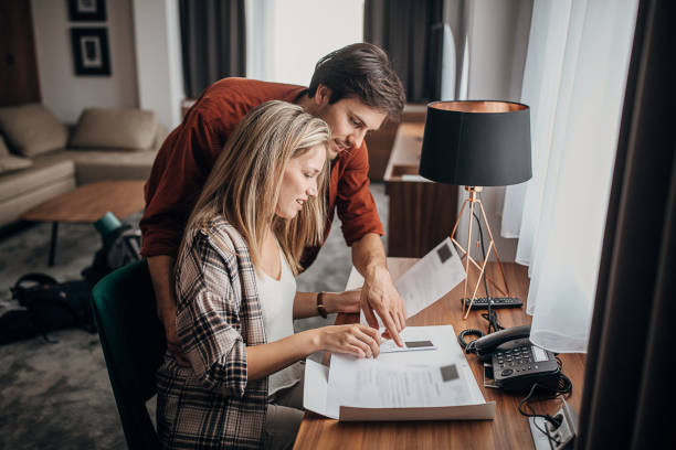 istock Beautiful young couple reading a guide in a hotel room 1252030096