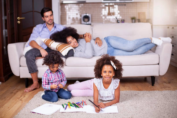istock Kids playing on floor, parents relaxing on sofa at home 1252043348