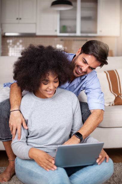 istock Young happy couple using laptop at home 1252044390