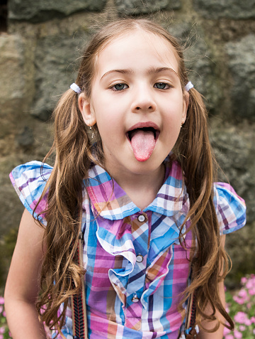Beautiful happy girl sticking tongue out with funny expression