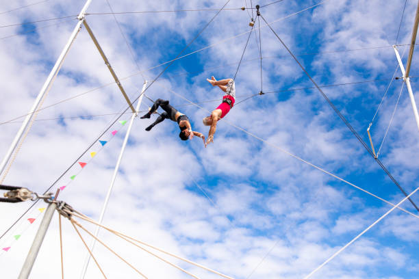 istock Active mature athlete jumping to the trapeze instructor in the sky 1252082041