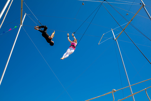 Trapeze artists jumping to the bar in the sky