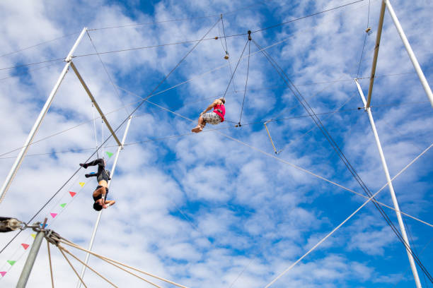 istock Two trapeze artist swinging in the sky 1252084120
