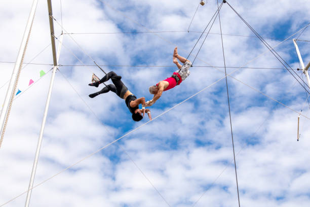 istock Active mature athlete jumping to the trapeze instructor in the sky 1252084638