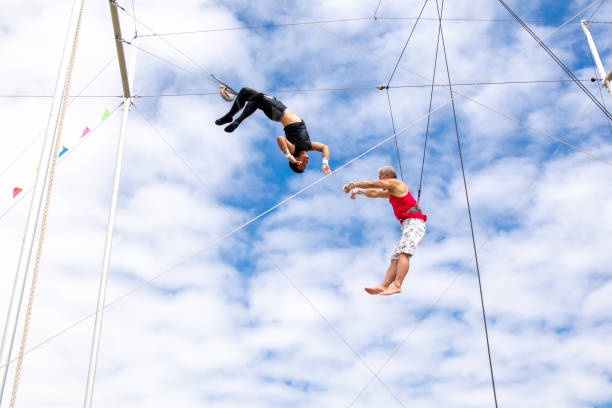istock Active mature athlete jumping to the trapeze instructor in the sky 1252085159