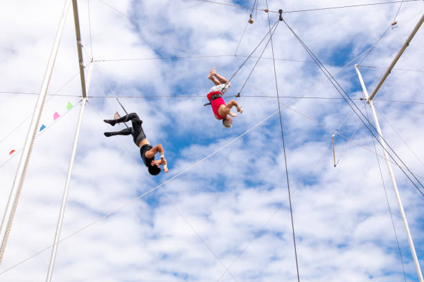 istock Active mature athlete jumping to the trapeze instructor in the sky 1252085677