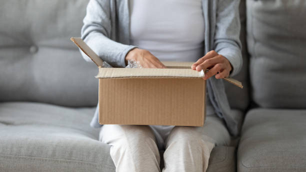 istock Woman open cardboard parcel with online shopping order 1252120548