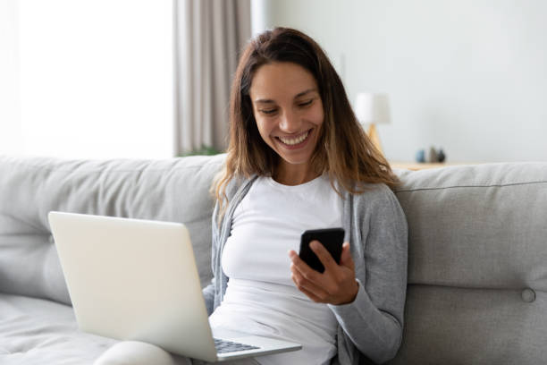 istock Happy millennial girl sit on couch multitask working on gadgets 1252120577