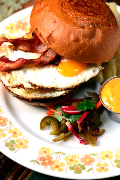 istock Bacon, Lettuce and Tomato, and fried egg or BLT sandwich served on toasted whole grain bread with mayonnaise and seasoned salt and pepper.  Classic America Resturant or diner breakfast or brunch sandwich favorite. 1252126871