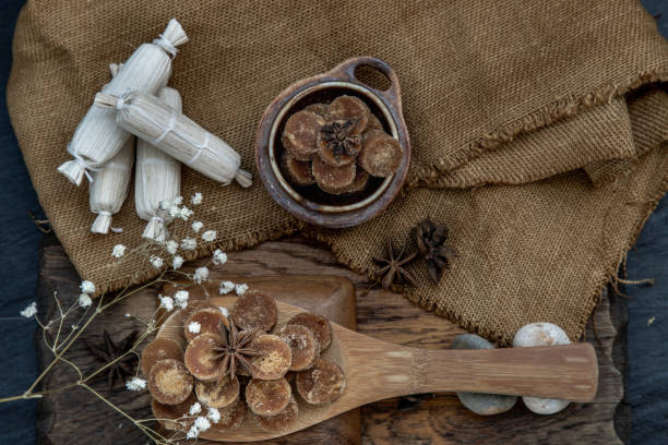 istock Brown cane sugar cube on wooden ladle and sackcloth. 1252127947