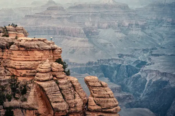 person standing on very edge of cliff in the grand canyon