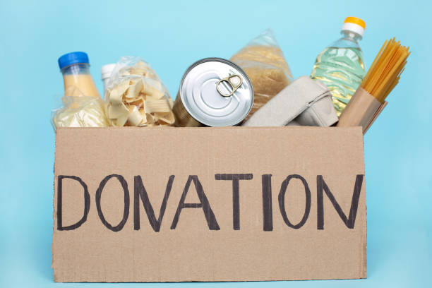 istock Donation box full of groceries on blue background. 1252178988