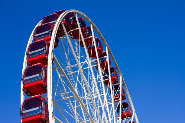 istock Red and white ferris wheel against a blue sky 1252191091