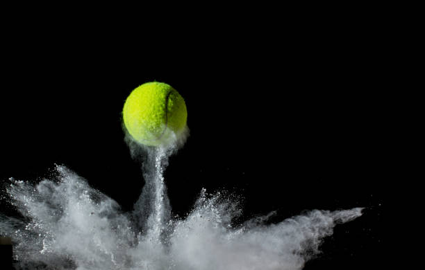 una pelota de tenis rebotando con fondo negro. - bouncing fotografías e imágenes de stock