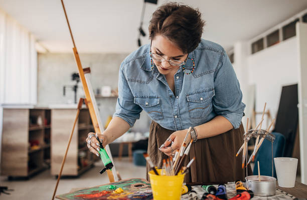 istock Cute female painter mixing colors in art studio 1252195423