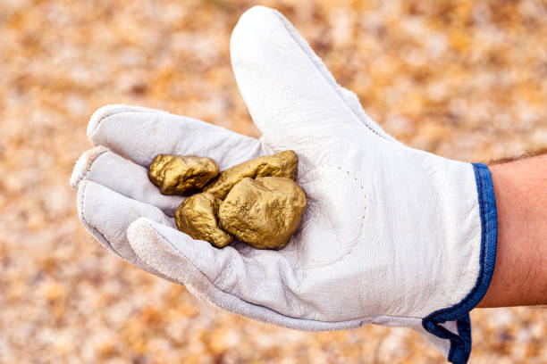 istock miner hand holding stones from another, gold mineral extraction, precious stone exploration concept. 1252197883
