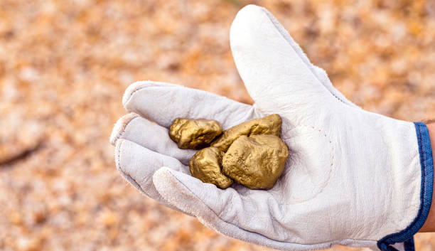 istock miner hand holding stones from another, gold mineral extraction, precious stone exploration concept. 1252197888