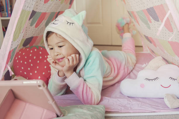 Mixed race Asian girl making facetime video calling with tablet at home, using zoom learning online app, social distancing, isolation, homeschooling education, learning remotely concept
