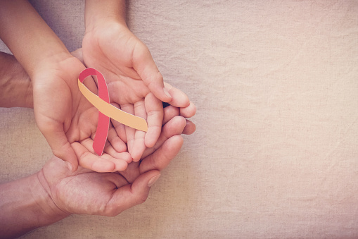 Adulto y niño sosteniendo cinta roja y amarilla, concepto del Día Mundial de la Hepatitis photo