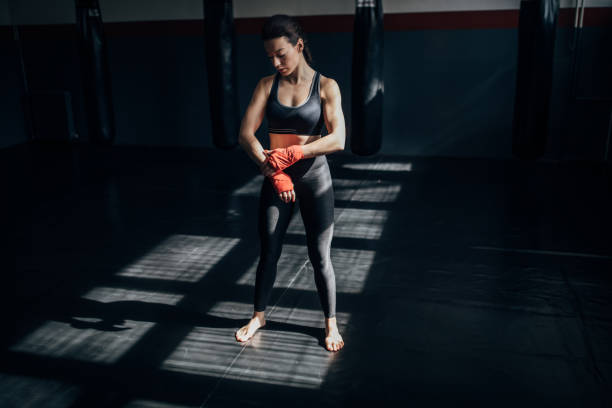 istock Beautiful female boxer standing alone in gym 1252204650