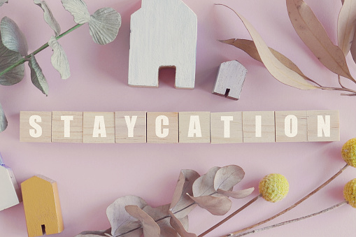 Wooden blocks with words STAYCATION, stay at home holidays concept