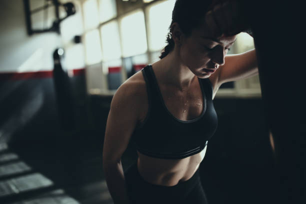 istock Beautiful female boxer standing alone in gym 1252205787
