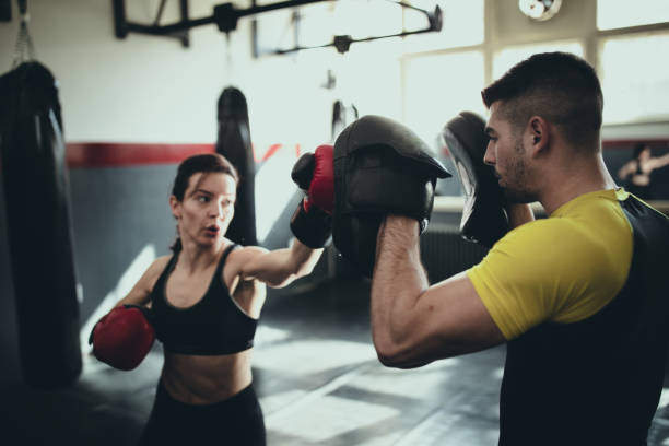 istock Female boxer training with her male coach in gym 1252205834