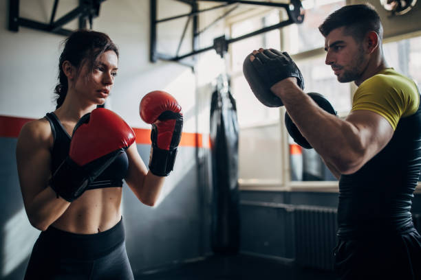 istock Female boxer training with her male coach in gym 1252205869