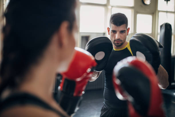 istock Female boxer training with her male coach in gym 1252205877
