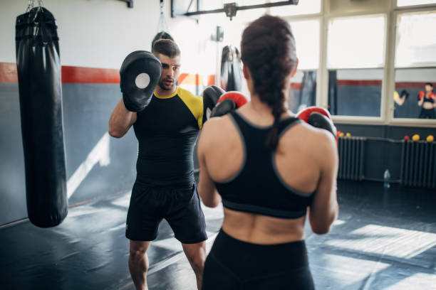 istock Female boxer training with her male coach in gym 1252205900
