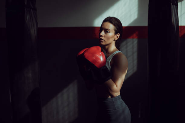 istock Female boxer standing alone in gym 1252209802