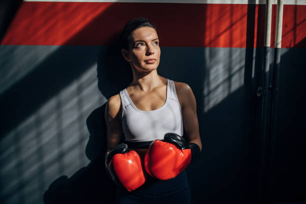 istock Female boxer standing alone in gym 1252209945