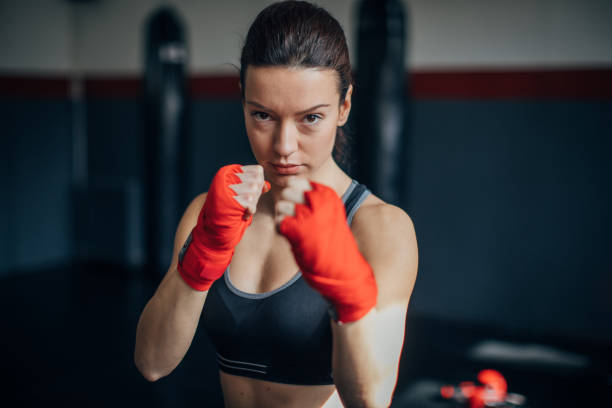 istock Female boxer standing alone in gym 1252209956