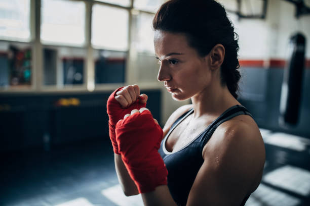 istock Female boxer standing alone in gym 1252209960