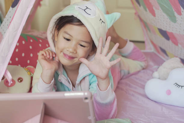 istock Mixed race Asian girl making facetime video calling with tablet at home, using zoom learning online app, social distancing, isolation, homeschooling education, learning remotely concept 1252209993