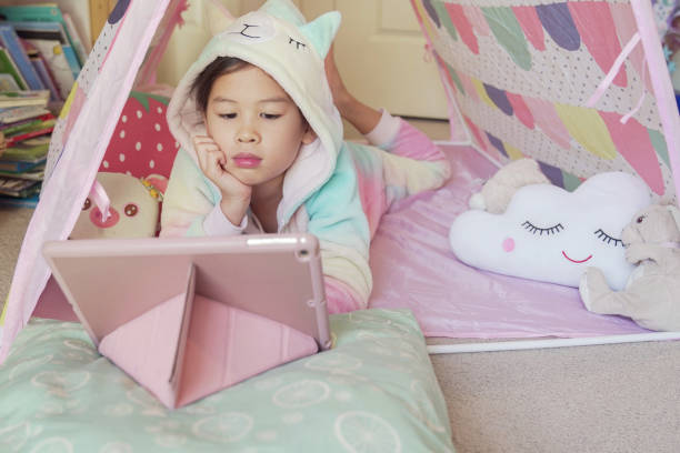 istock Mixed race Asian girl making facetime video calling with tablet at home, using  learning online app, social distancing, isolation, homeschooling education, learning remotely concept 1252212587