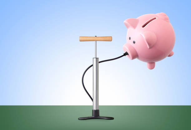 Savings growth. Pump inflates piggy bank. Piggy bank getting inflated by a pump. Concept photo. air pump stock pictures, royalty-free photos & images