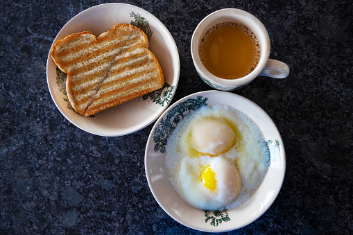 Traditional breakfast popular in Singapore and Malaysia consisting of half boiled eggs, kaya butter toast and cup of milk coffee. Kaya is a special spread made up sugar, coconut milk, eggs, and pandan leaves.
