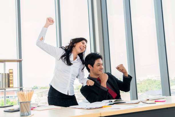 istock Two happy business people celebrate at office 1252247367