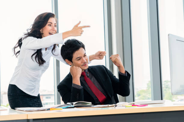 istock Two happy business people celebrate at office 1252247554