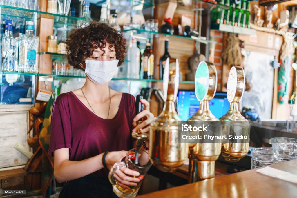 masked bartender filling beer Coronavirus Stock Photo