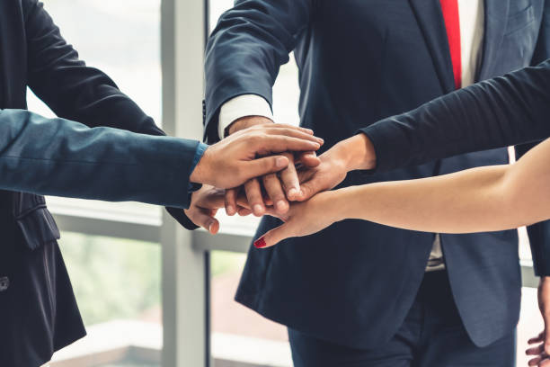 istock Many happy business people join hands together 1252249534