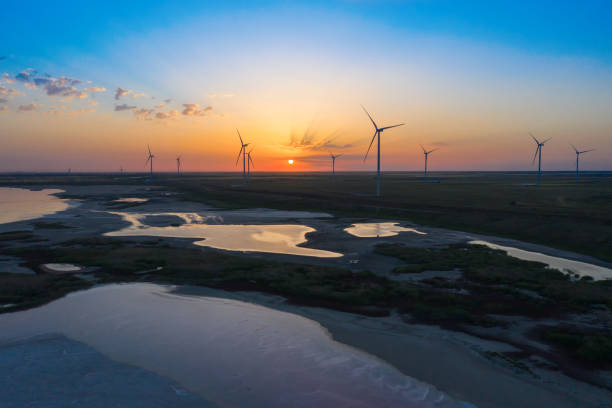 éolienne au beau coucher du soleil rouge orange - engineer wind turbine alternative energy energy photos et images de collection