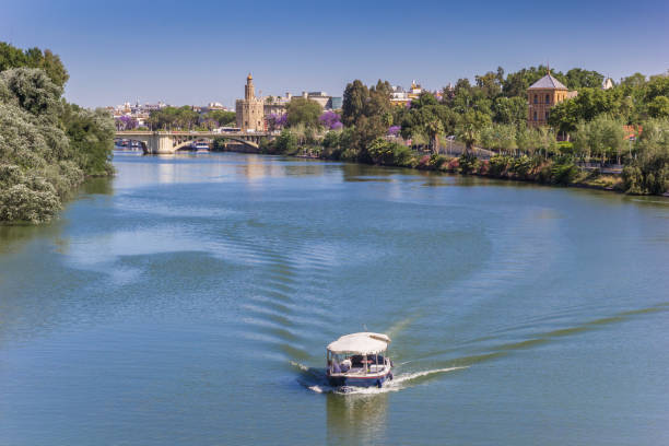 little boat on the river guadalquivir in sevilla - seville sevilla torre del oro tower imagens e fotografias de stock