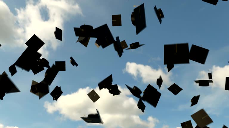 Graduation hats in the air on the blue sky background, university graduation