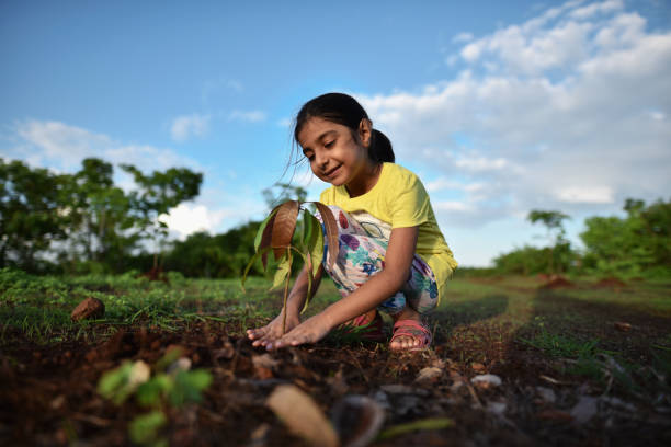 istock Smiling girl planting a tree 1252262786