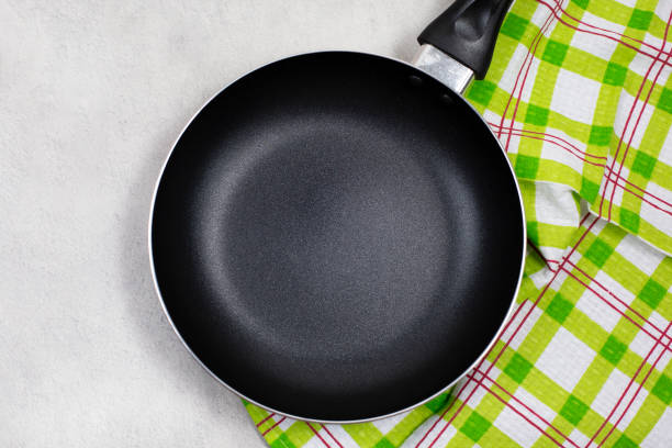istock Empty black frying pan or skillet with green kitchen towel 1252263128