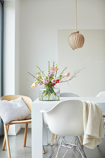 Different photos of a decorated white dining table in a bright environment with colorful flowers and simple flower vase