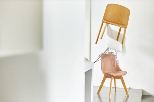 Modern orange stools and chairs of various designs on an orange painted floor and wall background.